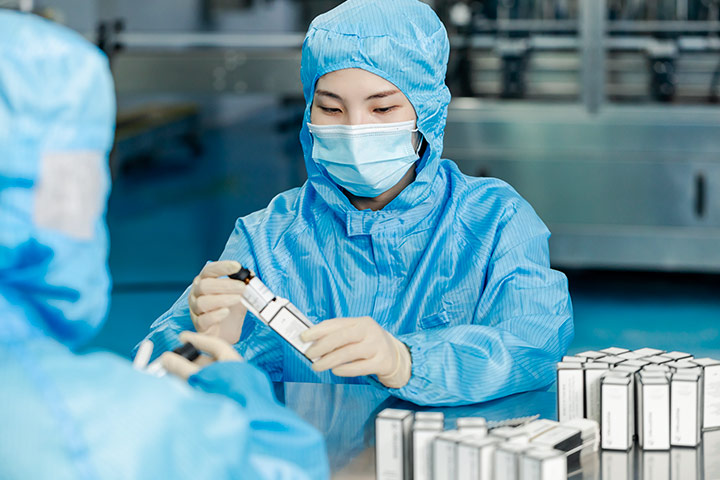 a worker in anti bacteria uniform is packaging the essential oils