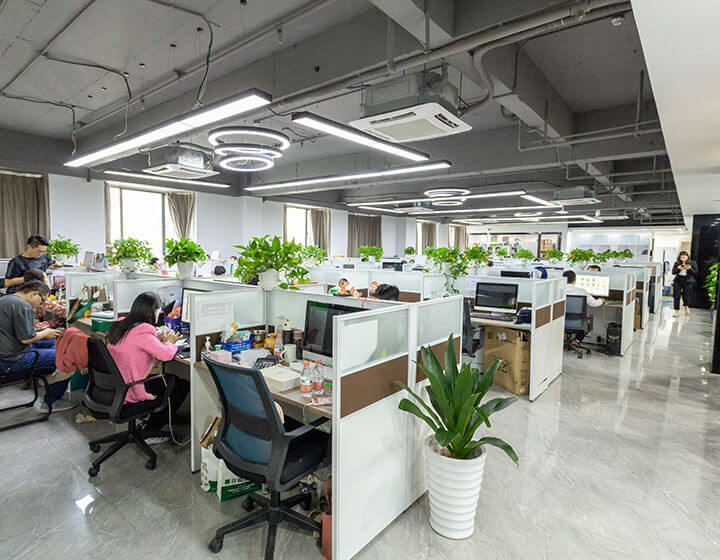office ares with desks, plants, and working staff